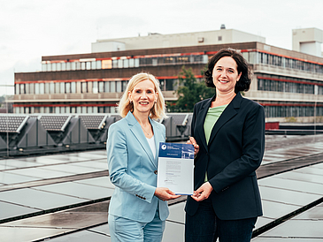 Professor Jutta Gnther, President of the University of Bremen, and Senator for the Environment, Climate, and Science Kathrin Moosdorf between the solar panels on the roof of the campus Mensa cafeteria.
